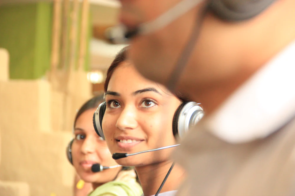 A support team wearing headsets in a bright office