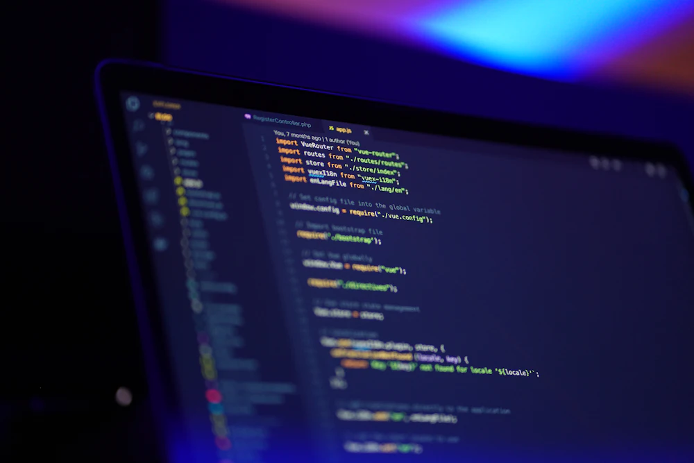 A laptop screen showing colourful source code